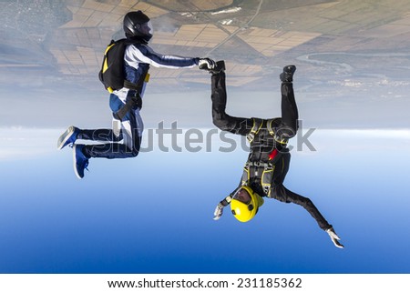 A girl and a guy skydivers perform pieces in free fall.