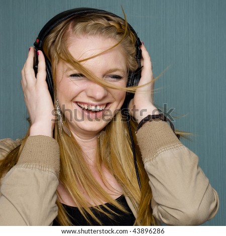 Beautiful Young Woman listening to music and dancing