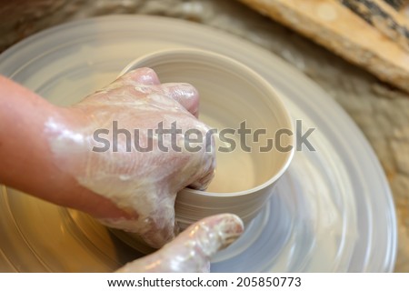 hands making pottery a shell