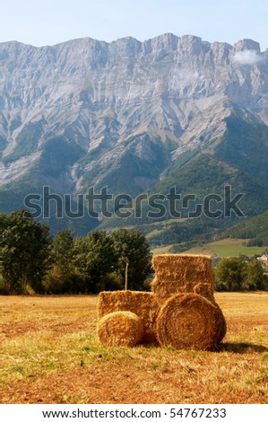 Straw Tractor in a field against a mountain