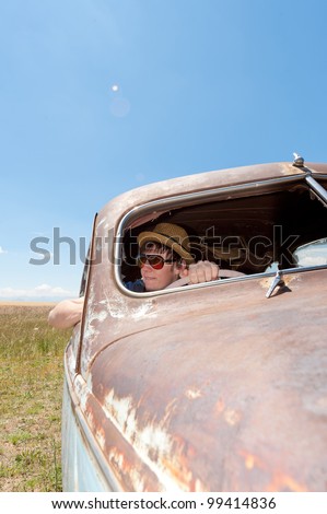 a girl and guy in old rusty car