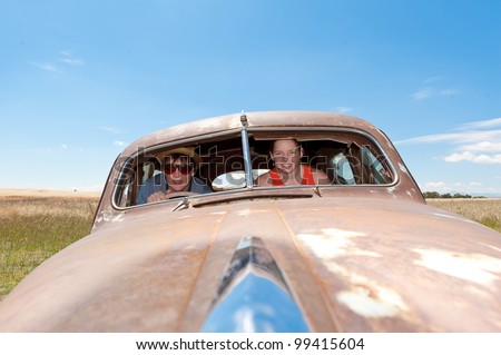Young guy and girl in a rusty old car