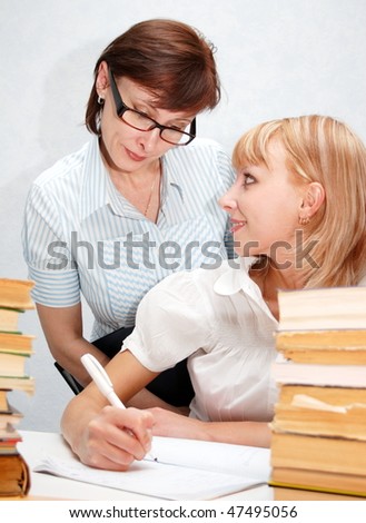 Female teacher supervises the student.