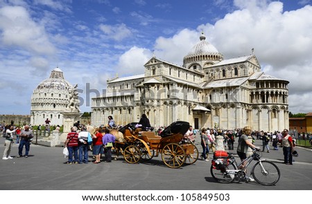 PISA, ITALY - JUNE 11: crowd of tourists and horse coach on the Unesco World Heritage site Piazza dei Miracoli with Dome and Baptistery on June 11, 2012 in Pisa, Italy
