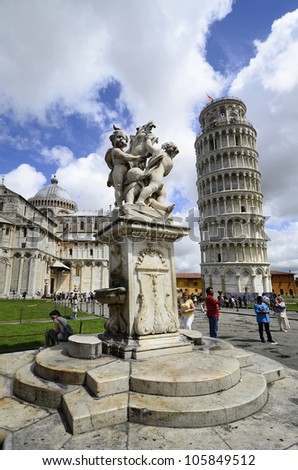 PISA, ITALY - JUNE 11: fountain sculpture and tourists round the Unesco World Heritage site Piazza dei Miracoli with Dome and  Leaning Tower on June 11, 2012 in Pisa, Italy