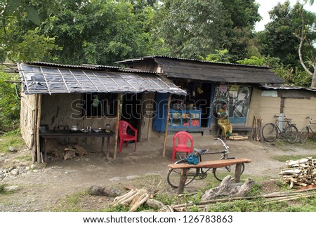 ASSAM, INDIA - SEPTEMBER 30: Unidentified woman in front of a humble kiosk with general store and tiny restaurant, people without any infrastructure live there, on September 30, 2007 in Assam, India