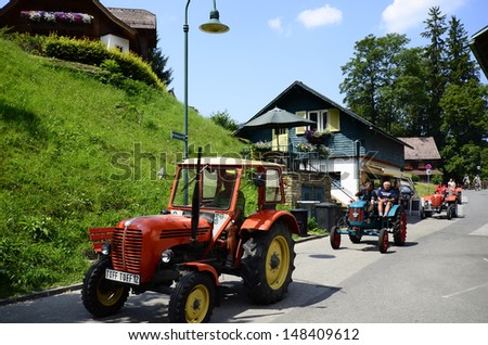 LUNZ, AUSTRIA - JULY 19: Unidentified people on vintage tractors, a exhibition together with the Ennstal Classic rallye for vintage cars, on July 19, 2013, in Lunz am See, Austria