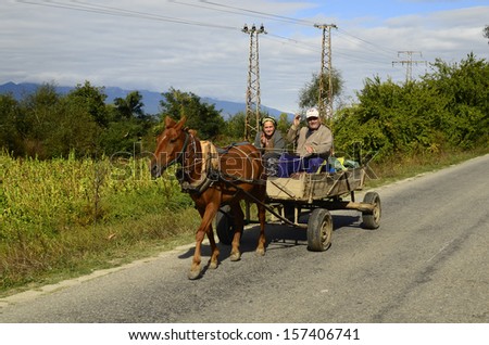 DABNIZA, BULGARIA - OCTOBER 02: Unidentified couple of friendly greeting peasants on horse cart in rural area in southern part of Bulgaria with tobacco fields, on October 02, 2013, Dabniza, Bulgaria