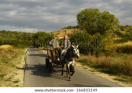 RILA, BULGARIA - SEPTEMBER  29: Unidentified friendly looking couple of peasants on horse cart in Rila valley, a traditional mode of transport in rural areas, on September 29, 2013 In Rila, Bulgaria