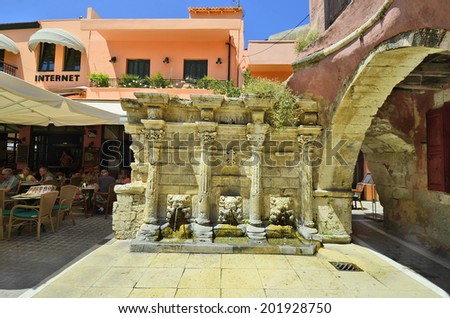 RETHYMNO, GREECE - MAY22: Unidentified people in restaurant beside Raimondi fountain and colorful home in the medieval city in Crete, on May 22, 2014 in Rethymno, Greece