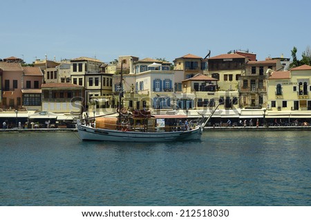 CHANIA, GREECE - MAY 27: Unidentified people, excursion boat and different restaurants and hotels on the harbor of the medieval village in Crete, on May 27, 2014, in Chania, Greece