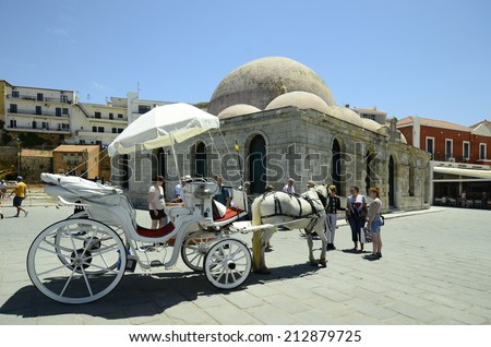 CHANIA, GREECE - MAY 27: Unidentified people and horse drawn coach in front of Janissaries mosque aka Hassan Pascha mosque in harbor of the medieval village in Crete, on May 27, 2014 in Chania, Greece