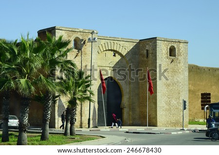 RABAT, MOROCCO - NOVEMBER 18: Unidentified people in front of the city wall with gate and place with palm trees, on November 18, 2014 in Rabat, Morocco