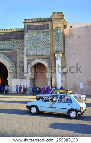MEKNES, MOROCCO - NOVEMBER 19: Unidentified people and petit taxi in front of Bab el-Mansour, petit taxis are a preferred mode of transport up to 4 persons, on November 19, 2014 in Meknes, Morocco