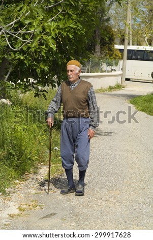 ANTALYA, TURKEY - APRIL 10: Unidentified elder man in traditional clothing with walking stick in a small rural village near Antalya; on April 10, 2009 in Antalya, Turkey