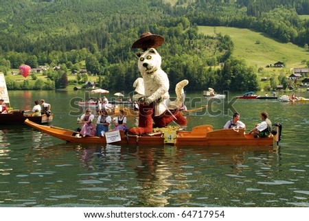 BAD AUSSEE, AUSTRIA - MAY 30: unidentified actors and spectators with boat on the Grundlsee-Lake and figures build with flowers by Narcissus Festival on May 30, 2005 in Bad Aussee in Styria, Austria