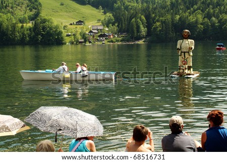 BAD AUSSEE, AUSTRIA - MAY 30: unidentified people on boat with flower-decorated sculpture by Festival of Narcissus on the Grundlsee(Lake) on May 30, 2005in Bad Aussee in Styria, Austria