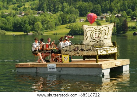 BAD AUSSEE, AUSTRIA - MAY 30: Unidentified people on boat with flower-decorated sculpture by Festival of Narcissus on the Grundlsee(Lake) on May 30, 2005in Bad Aussee in Styria, Austria
