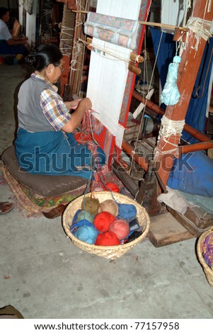 KATHMANDU, NEPAL - July 14: unidentified woman on a loom in a carpet weaving mill, a foundation to help and support tibetian people  on July 14, 2004 in Kathmandu, Nepal