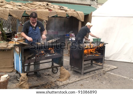 EGGENBURG, AUSTRIA - SEPTEMBER 11: unidentified cook on open fireplace grilling fish by the yearly medieval city festival in the village on September 11, 2005 in Eggenburg, Austria