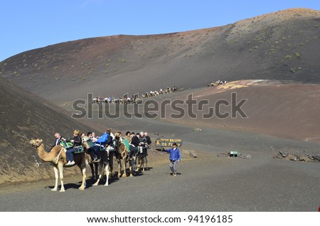 LANZAROTE, SPAIN - JANUARY18: camel riding for tourists to volcanic cones is a tourist attraction in the Timanfaya Nationalpark on the Canary Island- on January 18, 2012 in Lanzarote, Spain