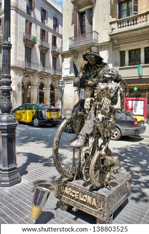 BARCELONA - MAY 29: Street Performer imitating bronze statue on a bicycle with a skeleton, famous La Rambla street, Barcelona, Catalunia, Spain on 29 May 2012.