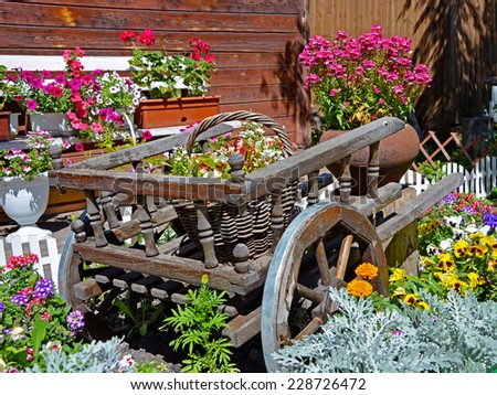 Old wooden cart, baskets and pots full of flowers