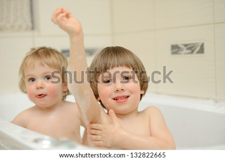 Two cute little boys having a bath together