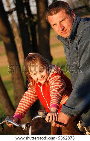 A father and daugther riding a bike outside
