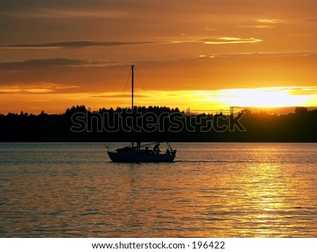 A silhouette of a family on a sailboat with a view toward Seattle.