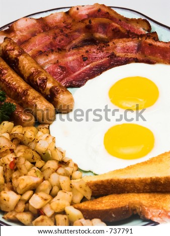 A traditional American breakfast of eggs, bacon, sausage, hash browns, and buttered toast.