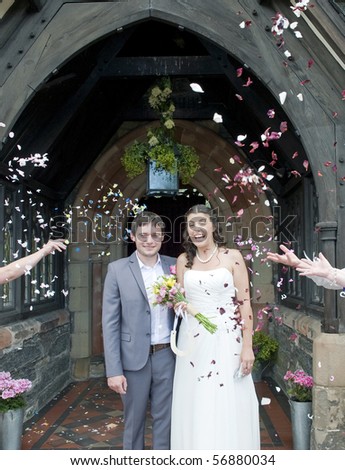 Closeup of Bride and Groom at church door with confetti being thrown