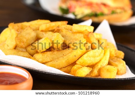 Crispy homemade French fries on metallic plate with ketchup (Selective Focus, Focus one third into the fries)