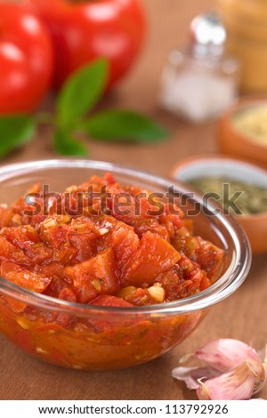 Glass bowl of fresh homemade tomato sauce for pizza made of fresh tomatoes, basil, garlic and oregano (Selective Focus, Focus one third into the tomato sauce)