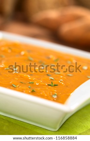 Bowl of fresh homemade sweet potato soup with thyme (Selective Focus, Focus one third into the soup)