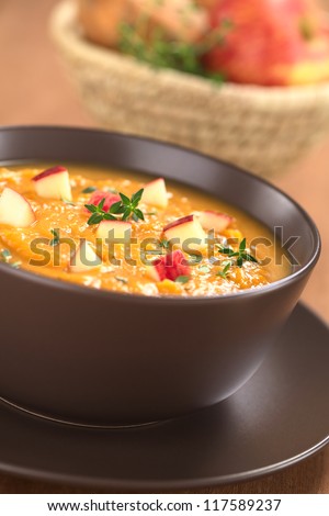 Bowl of fresh homemade sweet potato and apple soup with thyme (Selective Focus, Focus in the middle of the soup)