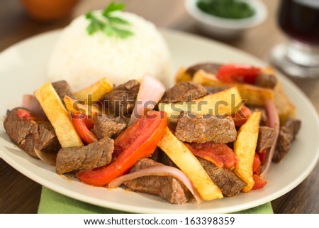 Peruvian dish called Lomo Saltado made of beef, tomato, red onion and French fries, served with rice (Selective Focus, Focus one third into the dish)