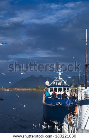 SVOLVAER, NORWAY - JULY 13, 2008: Unidentified people on boat at a landing stage on July 13, 2008 in Svolvaer, Norway. Svolvaer is on the Lofoten, which is a popular tourist destination.
