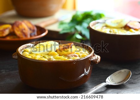 Ecuadorian traditional Easter soup called Fanesca, prepared from many different legumes, gourd, pumpkin, milk and salt cod (Selective Focus, Focus on the front of the egg slice and fried plantain)