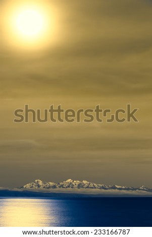 Lake Titicaca and the snow-capped mountains of the Andes photographed from the Isla del Sol (Island of the Sun) at night with the full moon shining