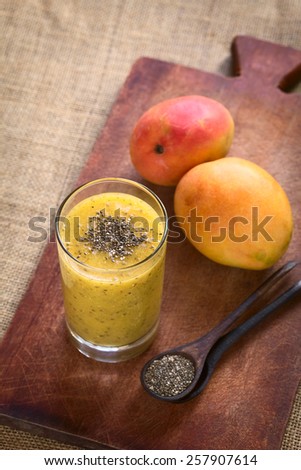 Chia seed (lat. Salvia hispanica) and mango juice photographed with natural light. Chia seeds are considered a superfood (Selective Focus, Focus on the chia seeds on the juice)