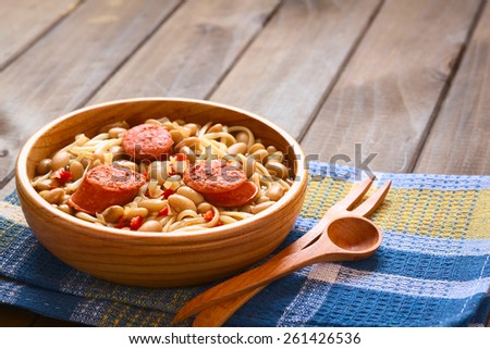 Chilean dish Porotos con Riendas (in English beans with reins) made of beans, linguine (flat spaghetti), fried sausage, photographed with natural light (Selective Focus, Focus one third into the dish)