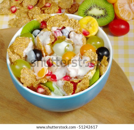 Fruits and Cereals with Joghurt in blue bowl on wooden board