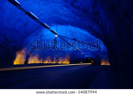 A tunnel with blue stopping bay with the front lights of a car (Long-time exposure)