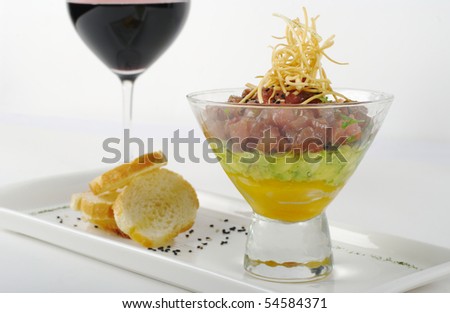 Starter out of Raw Tuna, Avocado and Mango in Glass, with Baguette and a Glass of Red Wine (Selective Focus)