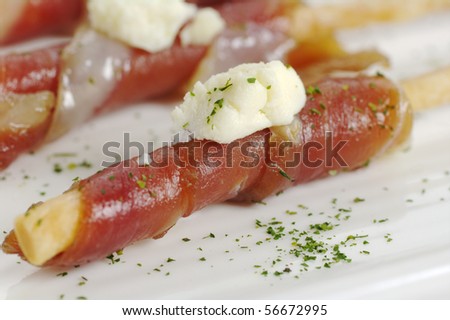 Appetizer: Bacon slice wrapped around salt stick with a piece of cheese on top (Selective Focus)