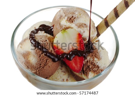 Vanilla and chocolate ice-cream, strawberry and waffle roll with chocolate sauce being poured over (Selective Focus)