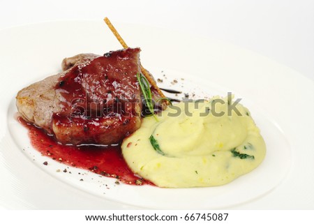 Mashed potato with meat, red sauce, fresh rosemary and a salt stick (Selective Focus, Focus on the front of the meat)