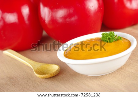 Peruvian hot salsa made of a red pepper called rocoto which is visible in the background (Selective Focus, Focus on the parsley)