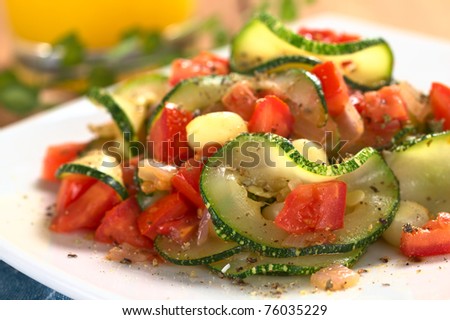 Sauteed zucchini slices, tomato cubes, onion and cooked corn grains with dried herbs and black pepper (Selective Focus, Focus on the front of the zucchini slice and tomato piece in the front)